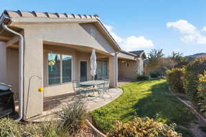 Rear view of house featuring a yard and a patio area