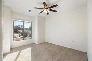 Unfurnished room featuring light colored carpet and ceiling fan