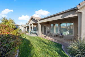 Rear view of house featuring a patio area and a lawn