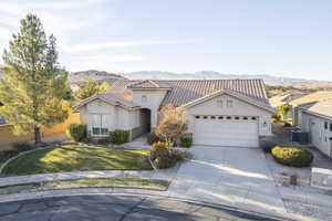 View of front of property featuring central AC, a garage, a mountain view, and a front yard