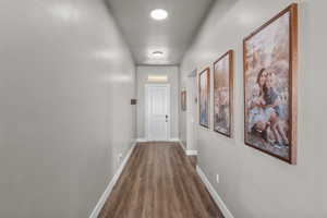 Corridor with dark hardwood / wood-style flooring and a textured ceiling