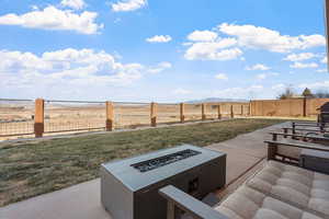 View of yard with a rural view, a mountain view, a fire pit, and a patio area