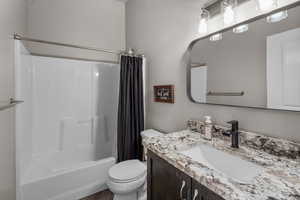 Full bathroom with vanity, shower / tub combo with curtain, and toilet