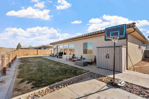 Back of property with a patio area, outdoor lounge area, and a lawn