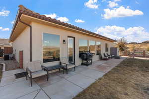 Rear view of property featuring a patio and central air condition unit