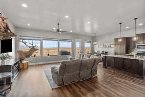 Living room with dark wood-type flooring, a textured ceiling, and a wealth of natural light