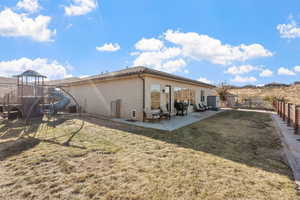 Rear view of house featuring a yard, a patio area, and a playground