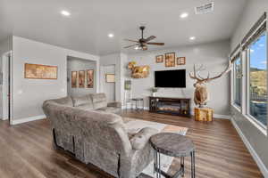 Living room featuring dark hardwood / wood-style floors and ceiling fan