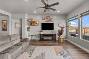 Living room featuring dark hardwood / wood-style flooring and ceiling fan