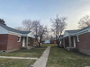 Property exterior at dusk featuring a yard