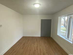 Empty room with hardwood / wood-style floors and a textured ceiling