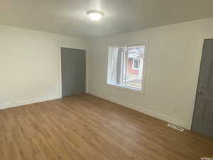 Unfurnished room featuring hardwood / wood-style floors and a textured ceiling