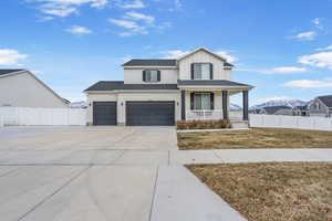 View of front of house with a porch, a garage, a mountain view, and a front yard