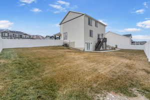 Back of house featuring central AC and a yard