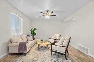 Living room with ceiling fan and light wood-type flooring