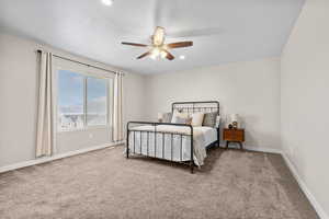 Bedroom with a textured ceiling, ceiling fan, and carpet