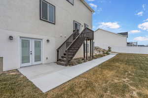 Doorway to property featuring a yard, a patio area, and french doors