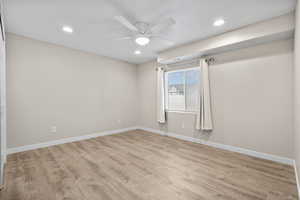 Unfurnished room featuring ceiling fan and light wood-type flooring