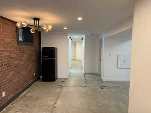 Unfurnished room featuring concrete floors and brick wall