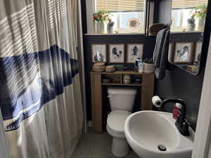 Bathroom with sink, toilet, and walk in shower