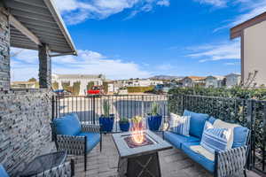 View of patio with a balcony and an outdoor fire pit