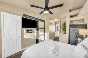 Bedroom with dark wood-type flooring and ceiling fan