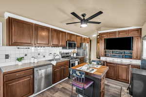 Kitchen featuring lofted ceiling, sink, a center island, dark hardwood / wood-style floors, and stainless steel appliances