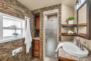 Bathroom with vanity and a shower with door