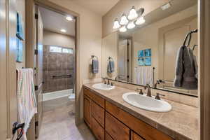 Full bathroom with tile patterned flooring, vanity, tiled shower / bath, and toilet