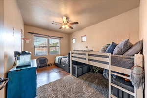 Bedroom with a textured ceiling and ceiling fan