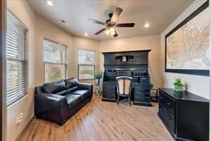 Home office with ceiling fan and light wood-type flooring