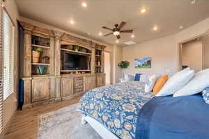 Bedroom with multiple windows, light wood-type flooring, and ceiling fan