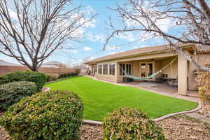 Rear view of house with a yard, a patio, and french doors