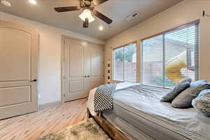 Bedroom with light hardwood / wood-style flooring, a closet, and ceiling fan