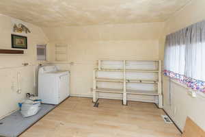 Washroom with washer / clothes dryer and light hardwood / wood-style floors