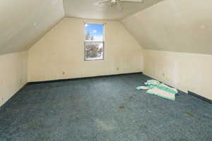 Additional living space with vaulted ceiling, carpet flooring, and ceiling fan