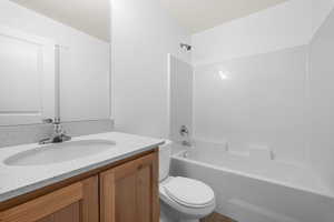 Full bath featuring shower / bathtub combination, vanity, and toilet