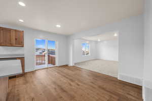 Unfurnished living room featuring light wood finished floors, baseboards, visible vents, and a wealth of natural light