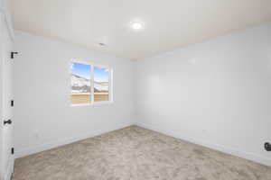 Empty room featuring light carpet, visible vents, and baseboards