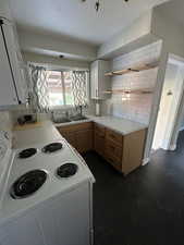 Kitchen featuring tasteful backsplash, sink, electric range, and light brown cabinets