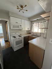 Kitchen with dark wood-type flooring, sink, white appliances, decorative backsplash, and white cabinets