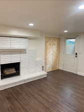 Unfurnished living room featuring dark wood-type flooring and a fireplace