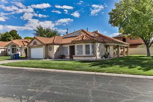 Mediterranean / spanish house featuring a garage, a front lawn, and solar panels