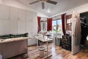 Bathroom with lofted ceiling, ceiling fan, hardwood / wood-style flooring, and a textured ceiling