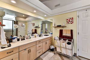 Bathroom with tile patterned flooring, vanity, and a raised ceiling