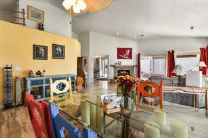 Living room with high vaulted ceiling, hardwood / wood-style floors, and a textured ceiling