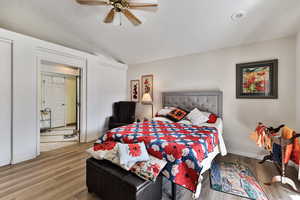 Bedroom featuring hardwood / wood-style flooring, ceiling fan, vaulted ceiling, and a textured ceiling