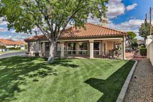 Rear view of house with a yard and a patio area