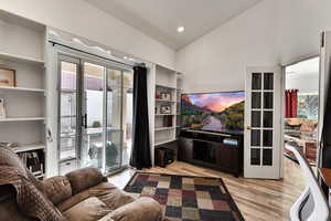 Living room with vaulted ceiling and light hardwood / wood-style flooring