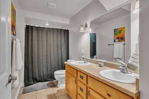 Bathroom with vanity, toilet, and tile patterned flooring